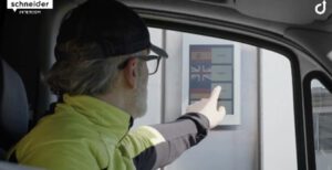 Person mit Basecap bedient Touchscreen mit Sprachauswahl